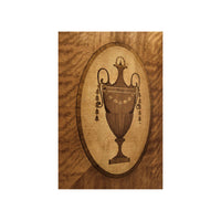 Urn motif detail on Hepplewhite demi-lune cabinet door.