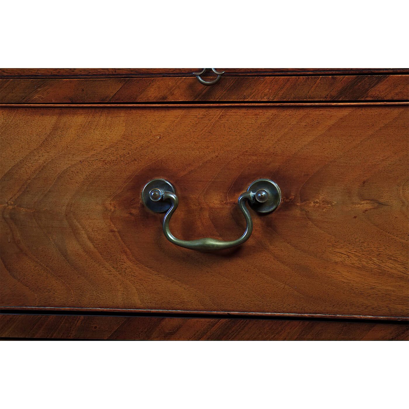 Close-up of handle on mahogany chest drawer.