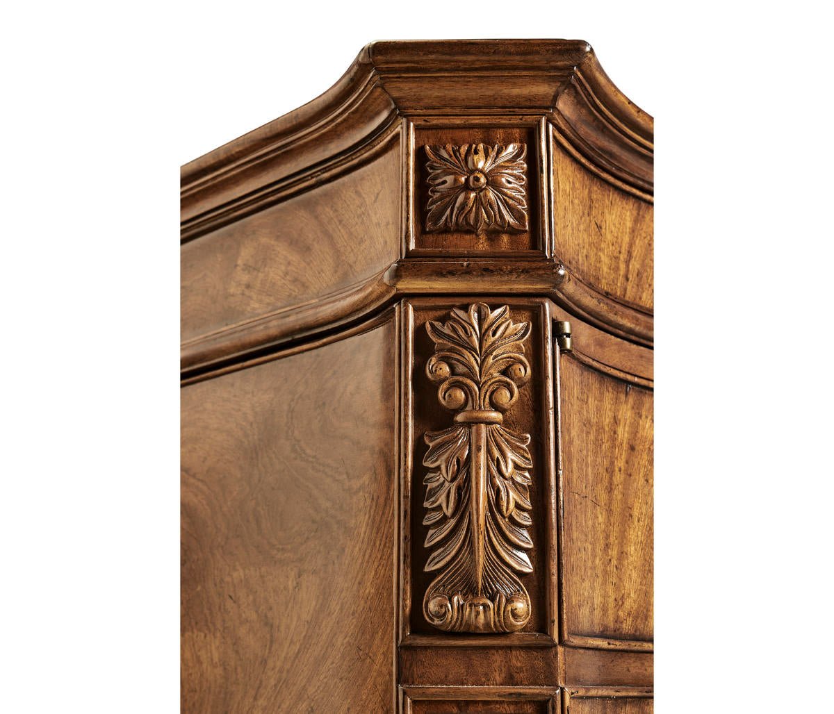 Carved floral detail on walnut desk corner.