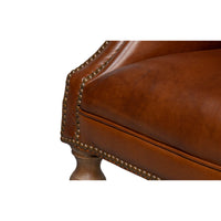 Leg and upholstery detail of leather wingchair.