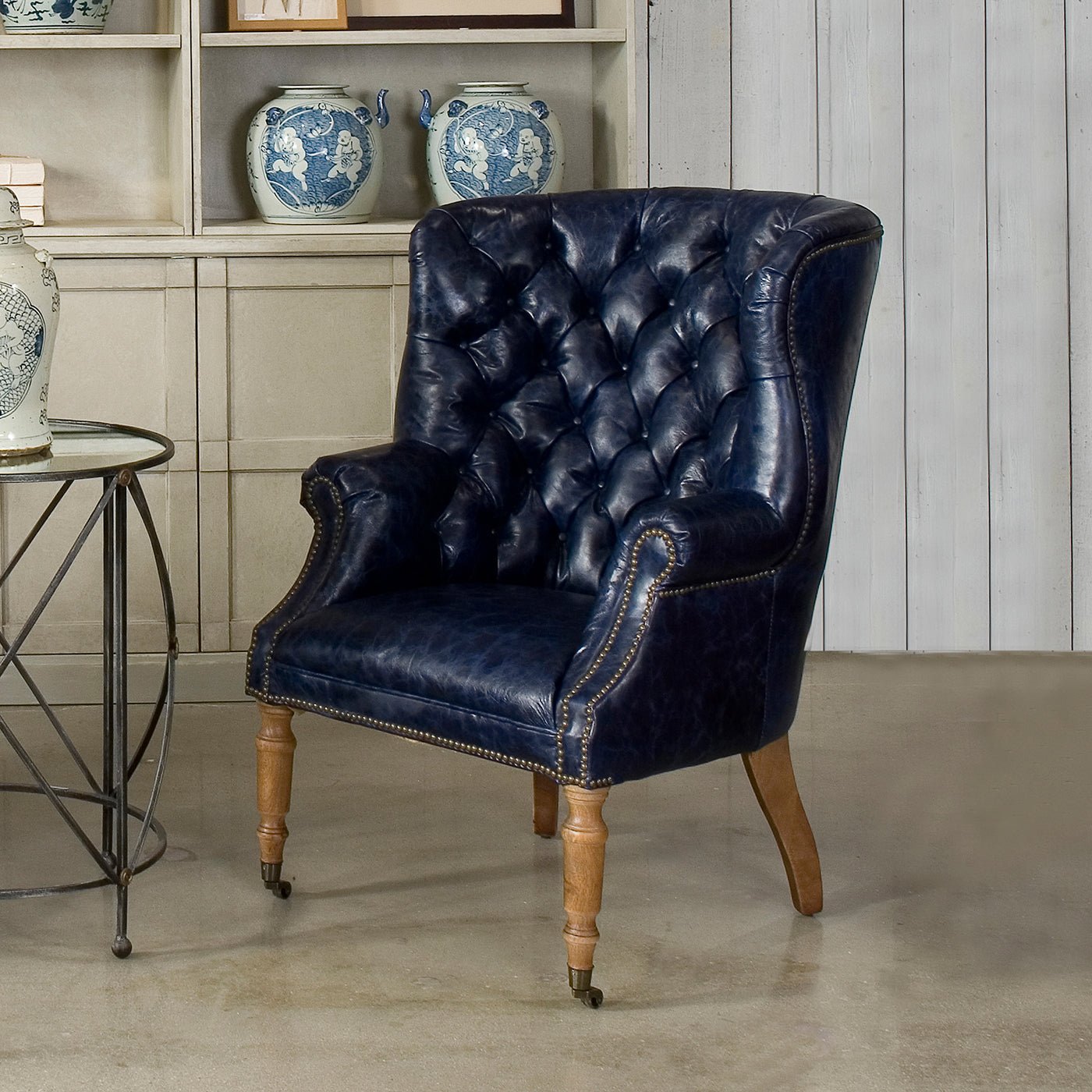 Blue wingchair in room setting, beside table.