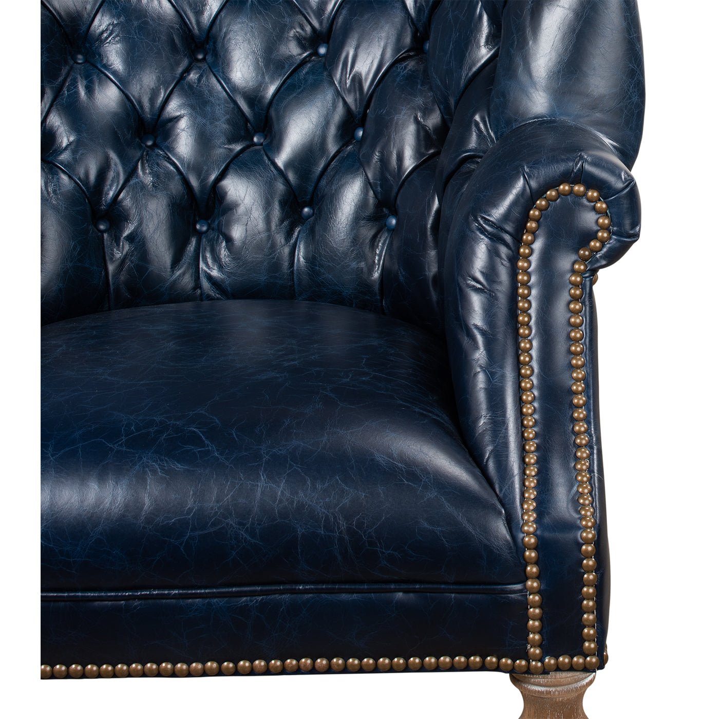 Close-up of blue wingchair armrest and tufting.