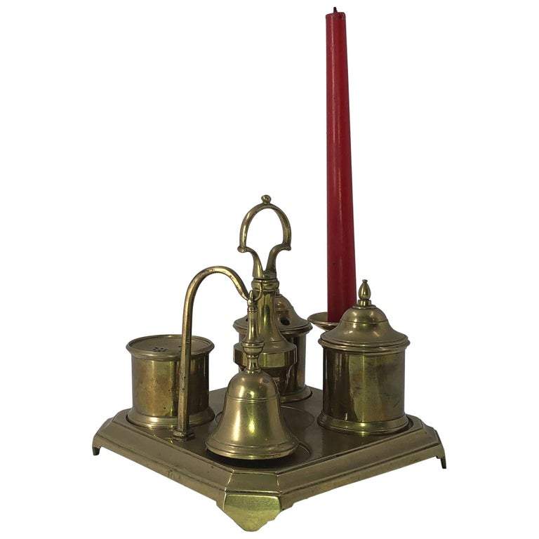 Brass inkwell set with red candle, front view.