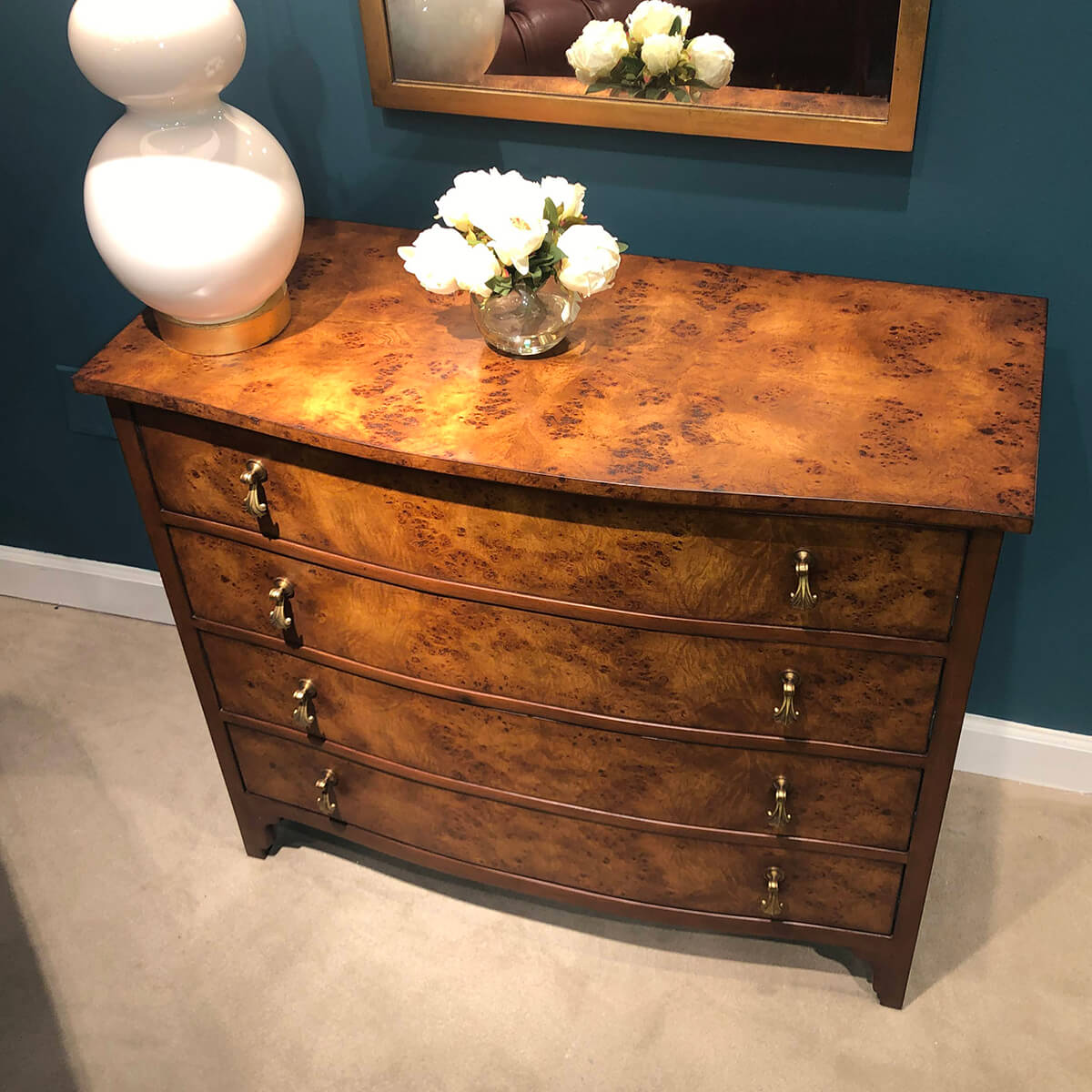 Wooden chest with lamp and flowers on top.