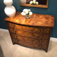 Wooden chest with lamp and flowers on top.