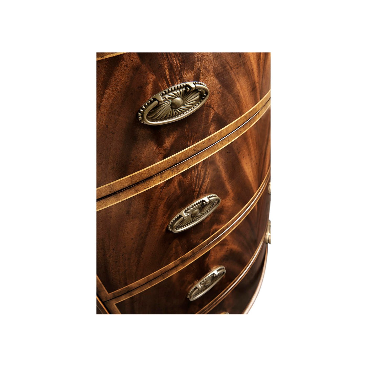 Close-up of drawer handles on demilune chest of drawers.