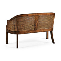 Wooden bench with cane backrest, rear angle view.