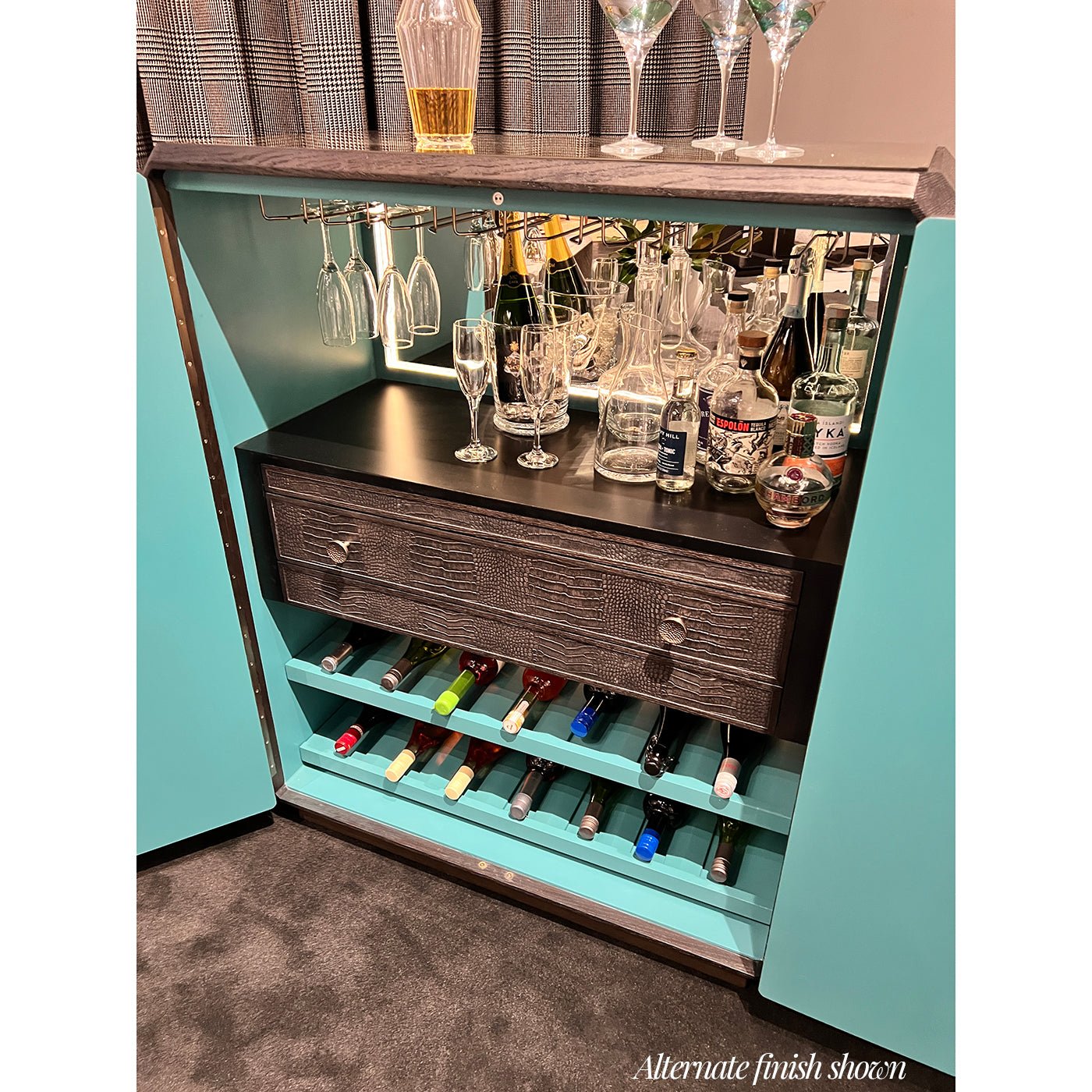 Close-up of bar cabinet interior, bottles and glasses shown.