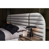 Gray channeled king bed headboard with nightstand and lamp.
