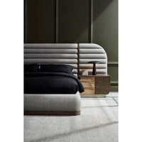 Side view of gray channeled king bed and nightstand.