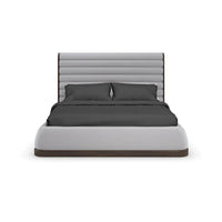 Front view of gray channeled king bed with pillows.
