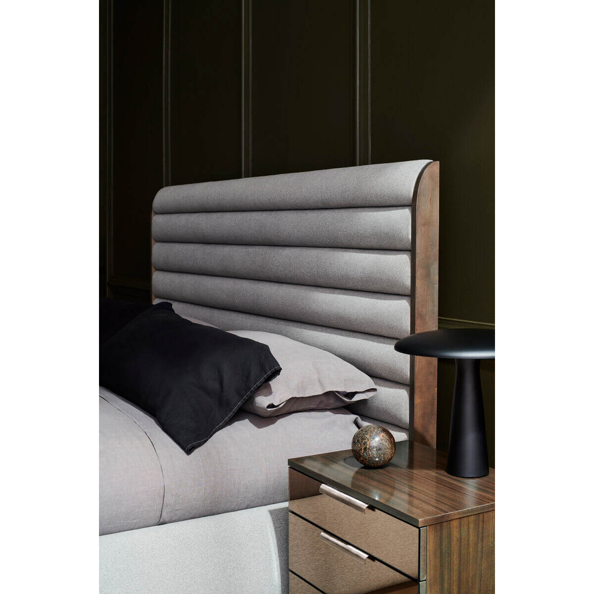 Close-up of the gray channeled king bed headboard.