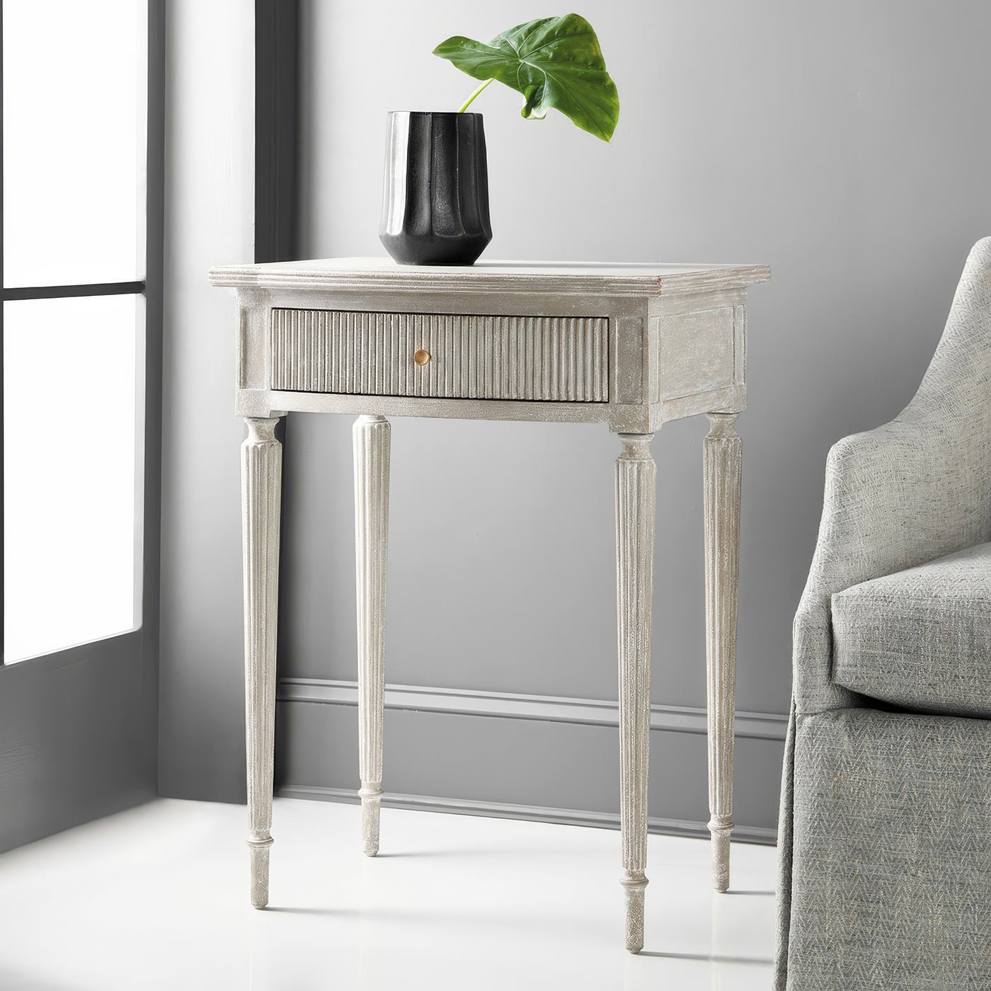 Styled gray Gustavian side table in modern interior.