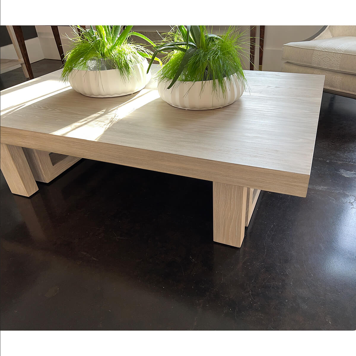 Coffee table with green plants on top, dark floor