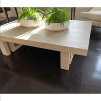 Coffee table with green plants on top, dark floor