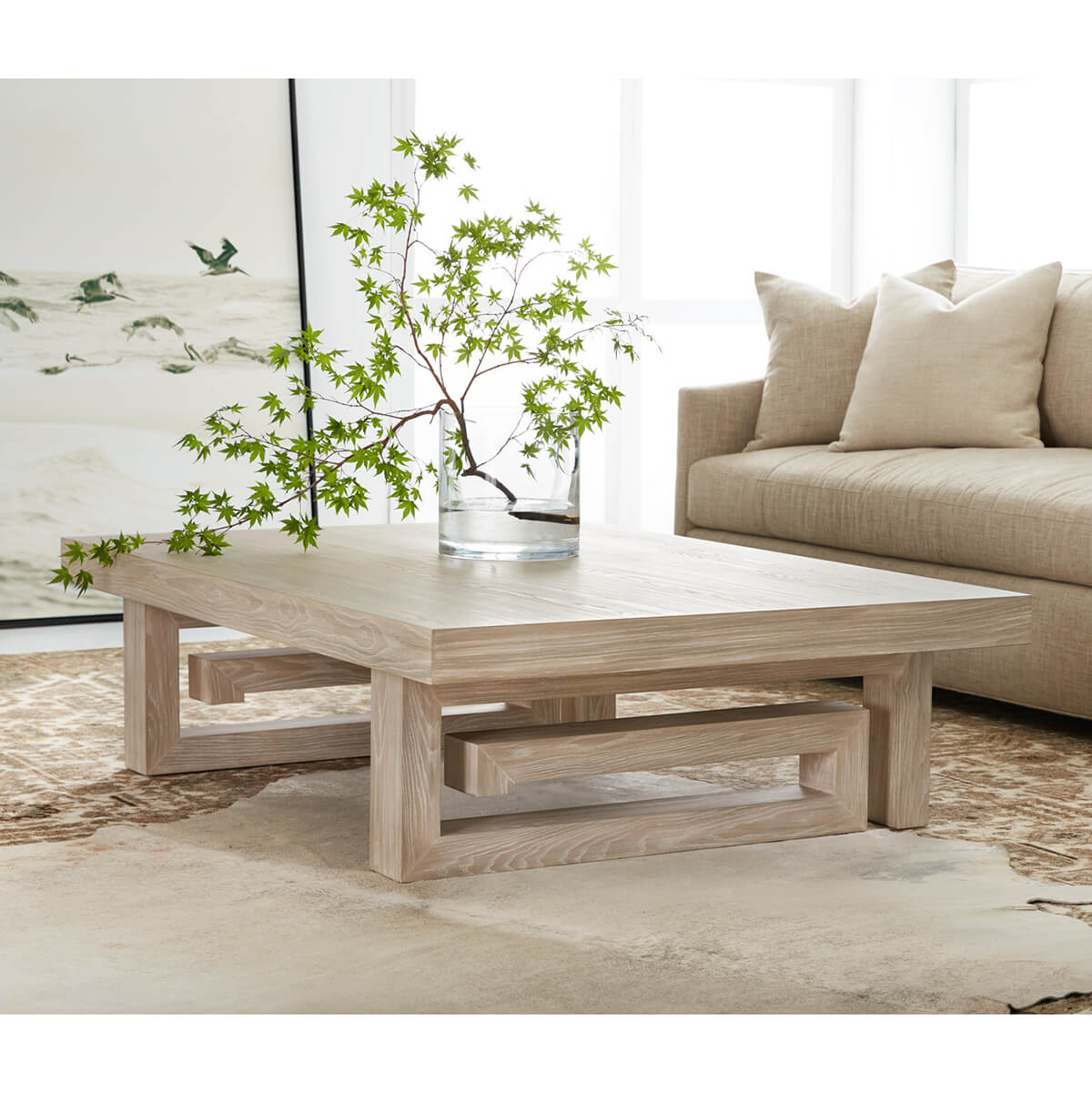 Coffee table styled with branches, beige sofa background