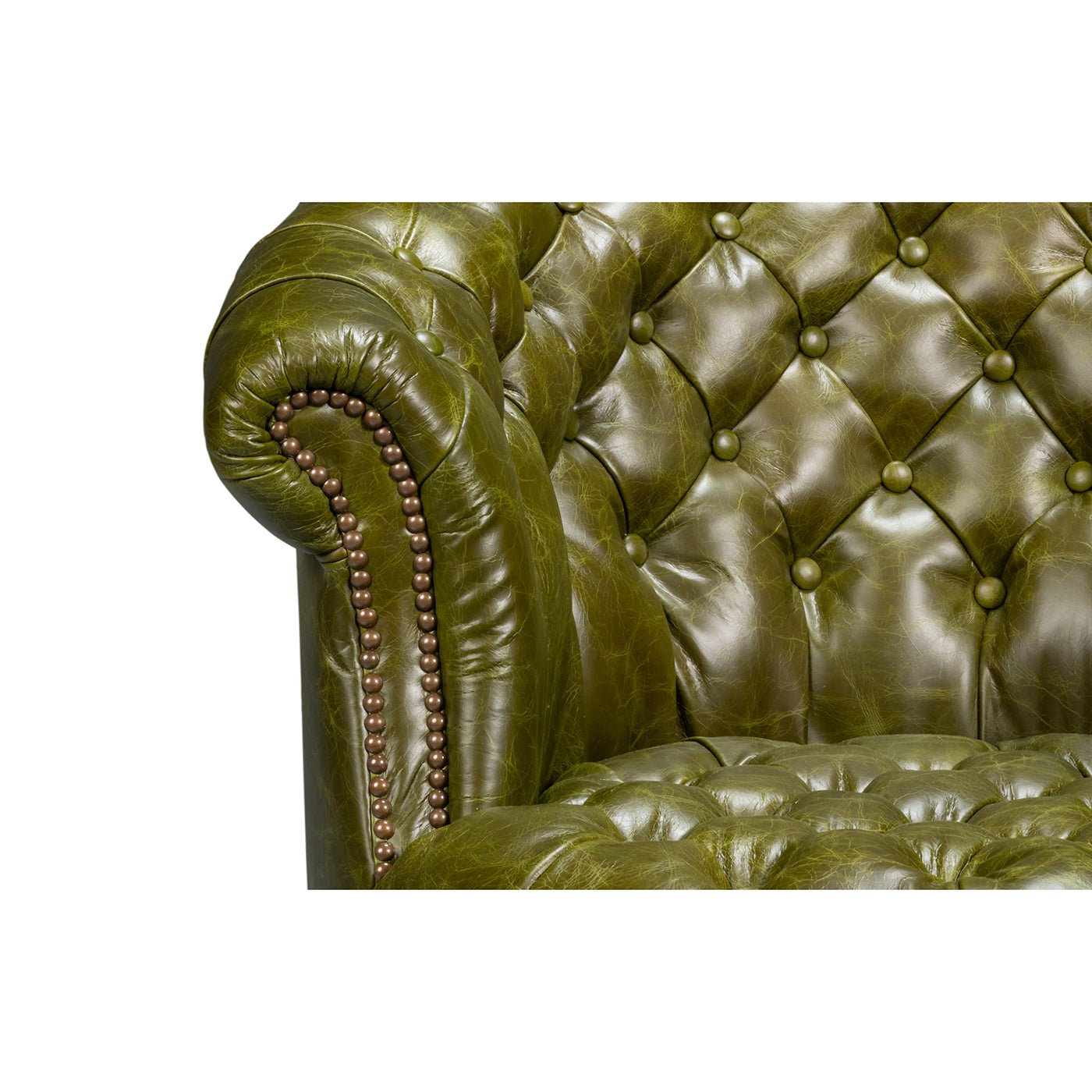 Green leather barrel back chair, armrest and tufting detail.