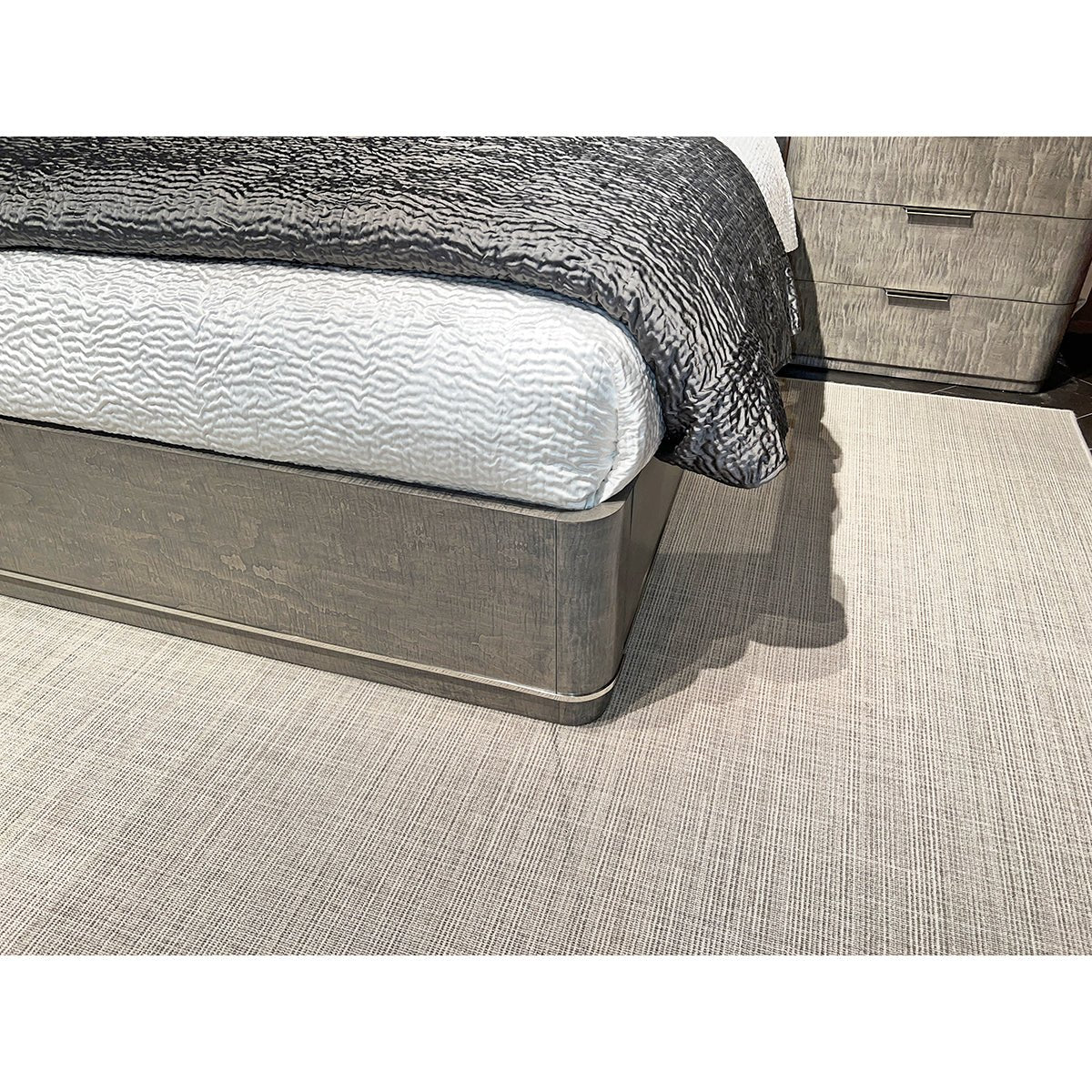 Corner detail of Grey Art Deco bed frame with comforter.