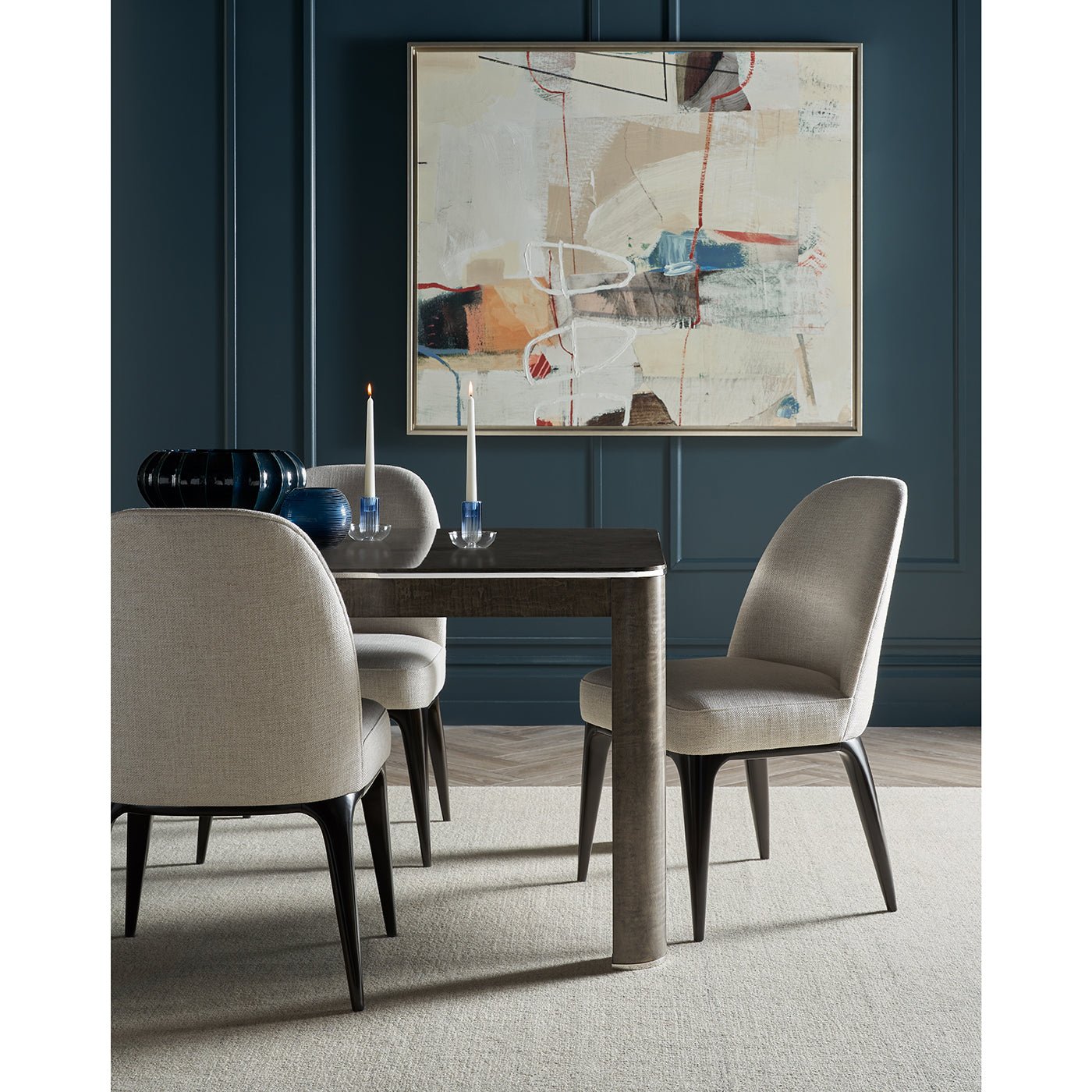 Dining setup with grey table and art in background.