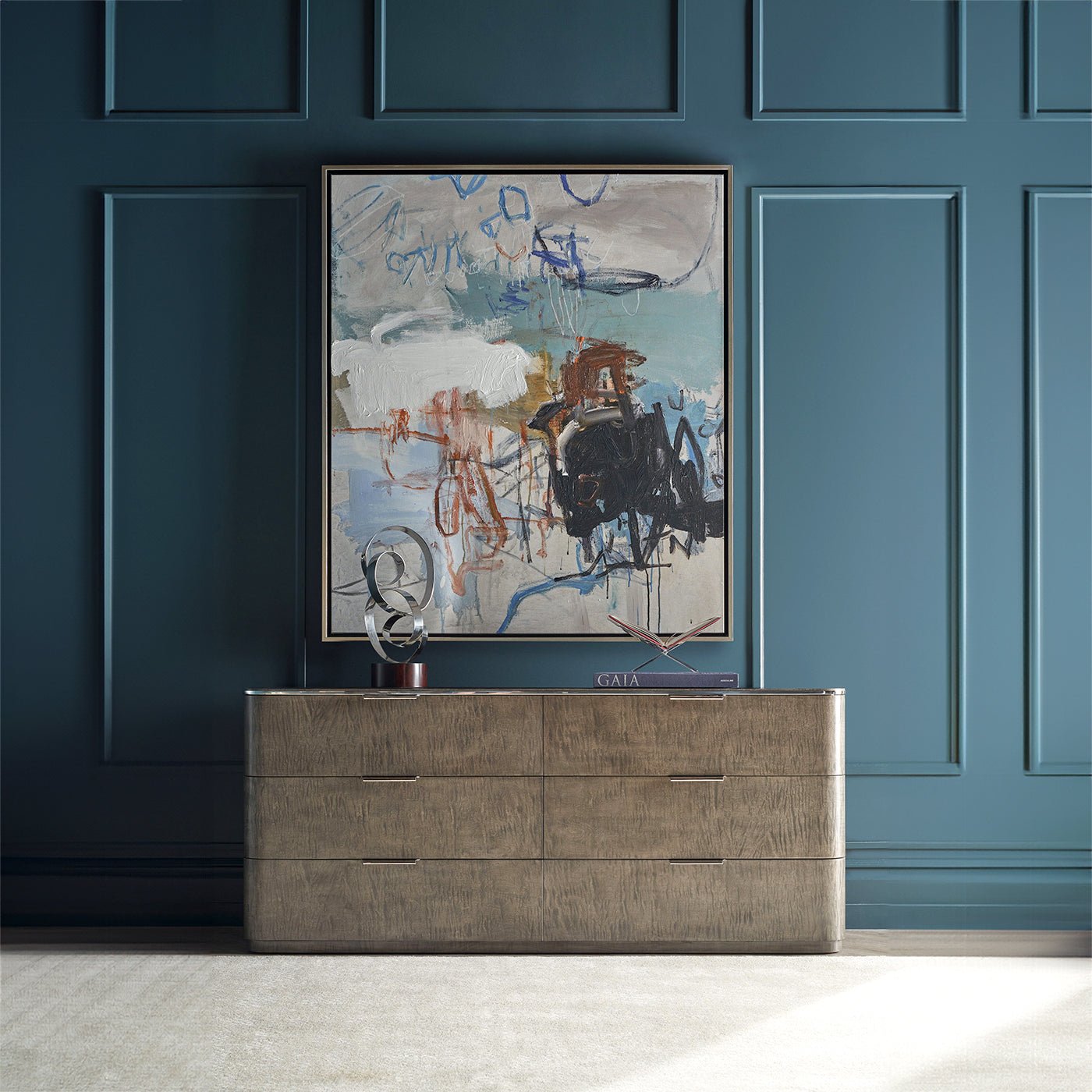 Dresser beneath large abstract artwork on blue wall.