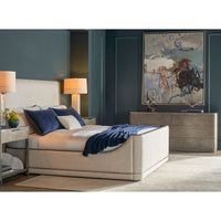 Bedroom with bed, dresser, art decor on wall.