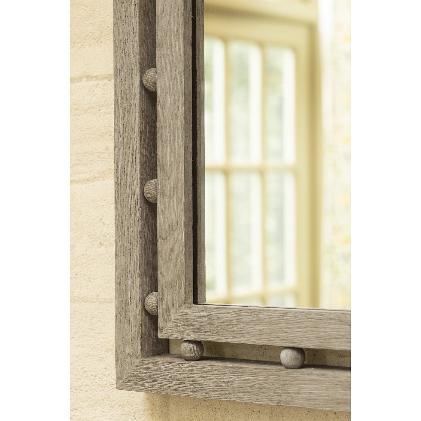 Corner frame detail of greyed oak mirror in a room