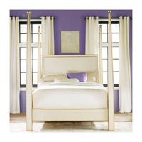 Cream four poster bed in purple-walled bedroom.