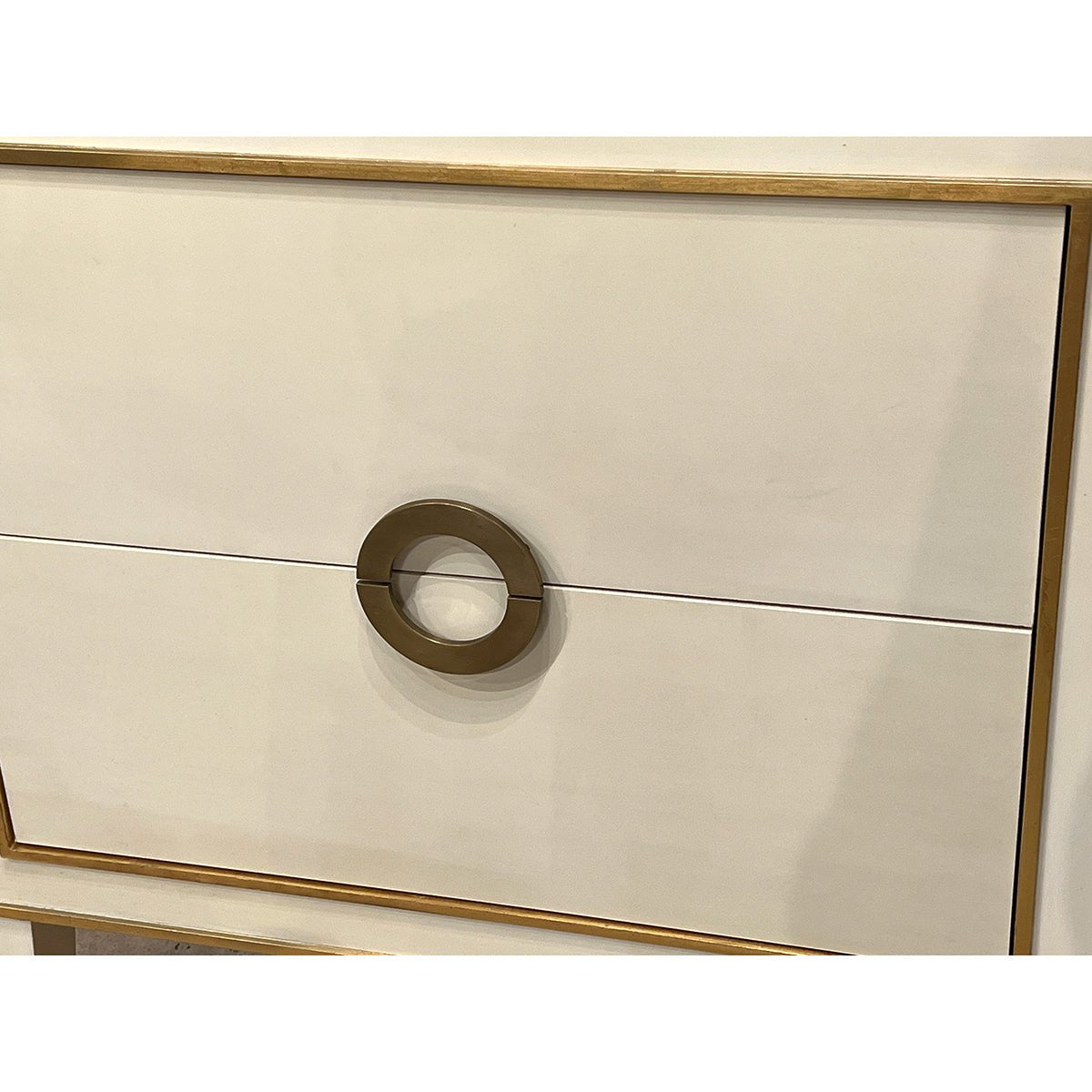 Close-up of nightstand drawer handle and gold trim.