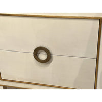 Close-up of nightstand drawer handle and gold trim.