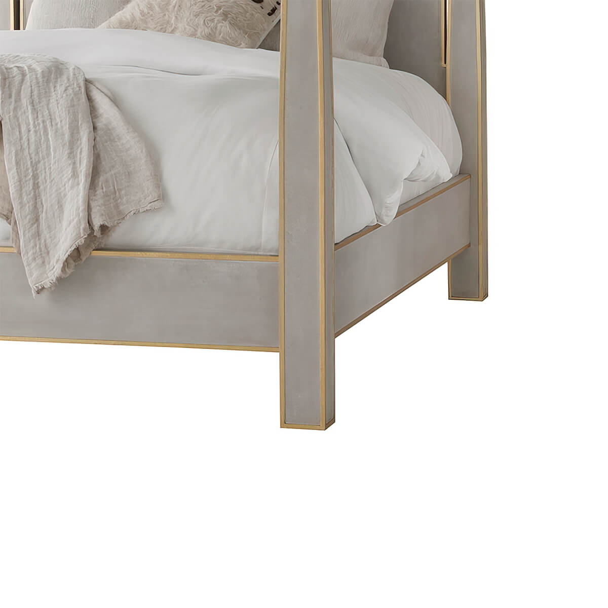 Bed corner close-up, grey upholstery and gold trim.