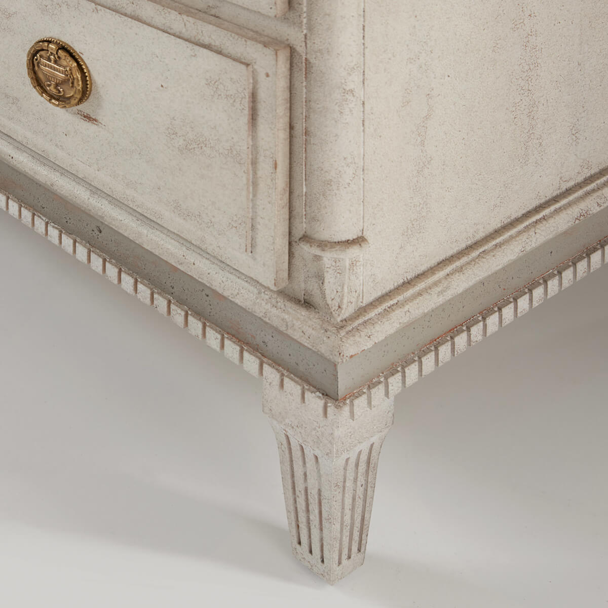 Corner detail of dresser leg with decorative trim.
