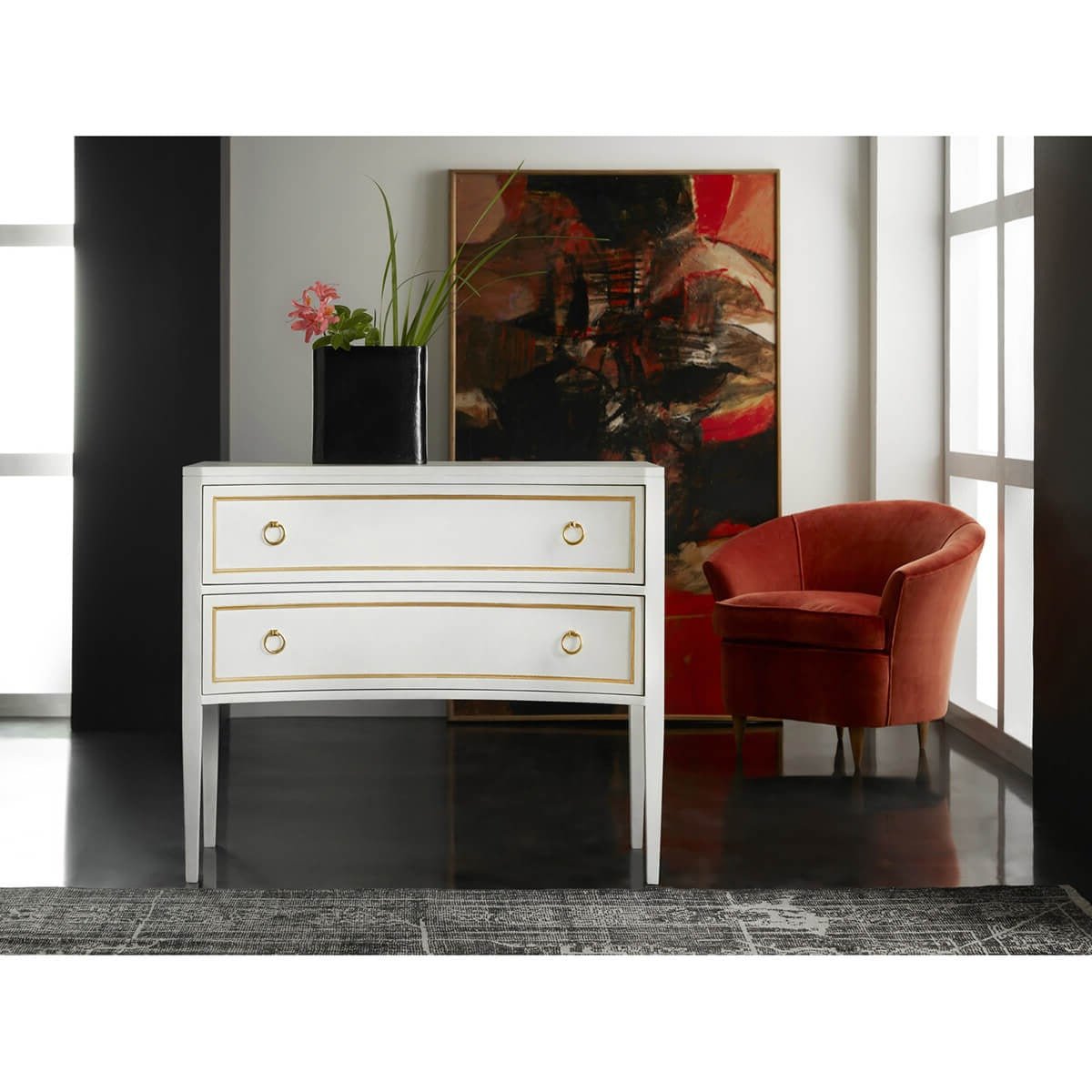 White dresser in modern interior setting with red chair.
