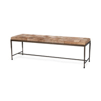 Angled view of the Canyon Sand hair-on-hide bench with a patchwork seat, slim iron frame and low stretcher