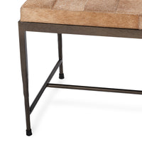 Close-up of the Canyon Sand bench’s tapered iron leg, lower stretchers and patchwork hide seat