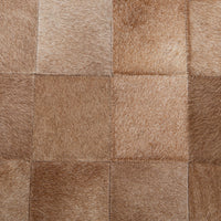 Close-up of the Canyon Sand bench’s hair-on-hide upholstery with stitched tan and cream patches