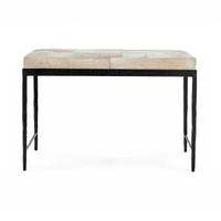 Front view of the Dusty Cream hair-on-hide bench showing its patchwork cushion and embossed black iron apron