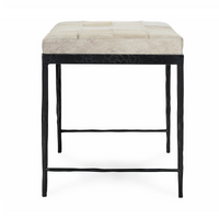 End view of the Dusty Cream hair-on-hide bench showing tapered black iron legs and low crossbars