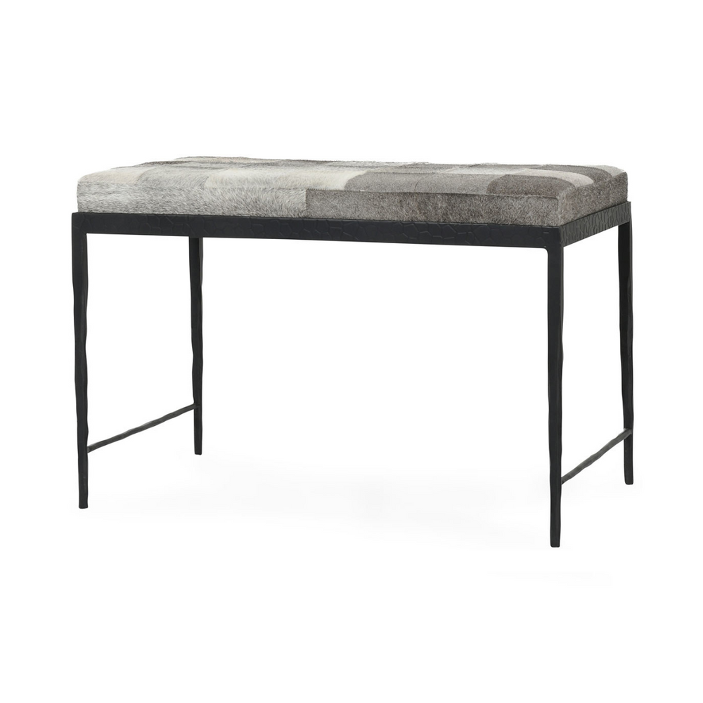 Angled view of the 28-inch Sparrow Gray hair-on-hide bench with patchwork cushion and hammered iron base