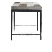 End view of the compact Sparrow Gray bench showing the hair-on-hide seat and iron legs with crossbars