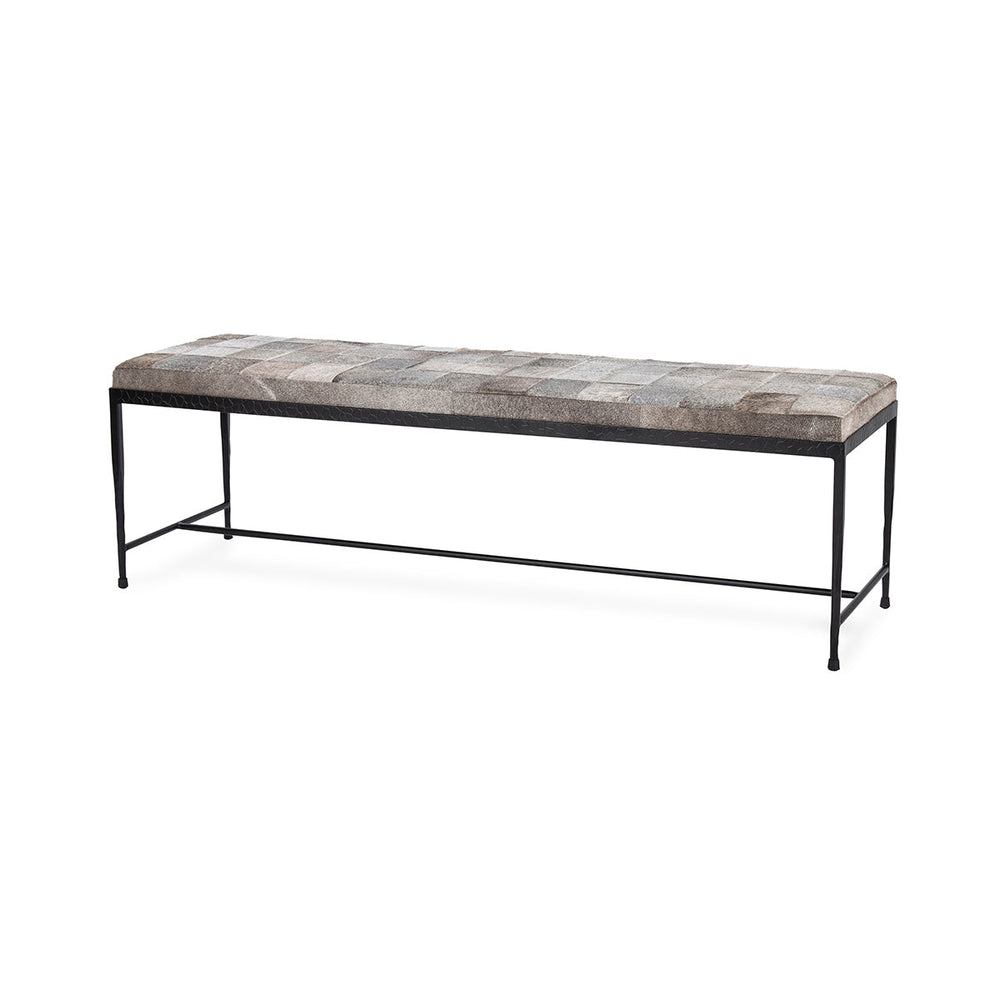 Angled view of the 60-inch Sparrow Gray hair-on-hide bench with patchwork seat, black iron frame and low stretcher