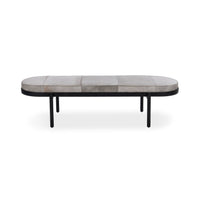 Front view of the gray hair-on-hide bench with a long oval seat and inset black iron legs