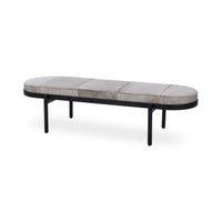 Gray hair-on-hide bench at an angle, with an oval patchwork seat, black iron rim and slender legs