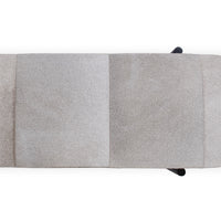 Overhead detail of the oval bench seat showing broad gray hair-on-hide panels and stitched seams