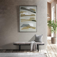 Gray oval hair-on-hide bench beneath abstract wall art, styled with a pillow and fringed throw