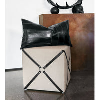 Harness cube ottoman with decorative pillow on top.