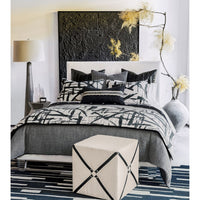 Bedroom with harness cube ottoman next to bed.