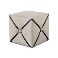 Beige harness cube ottoman with black straps.