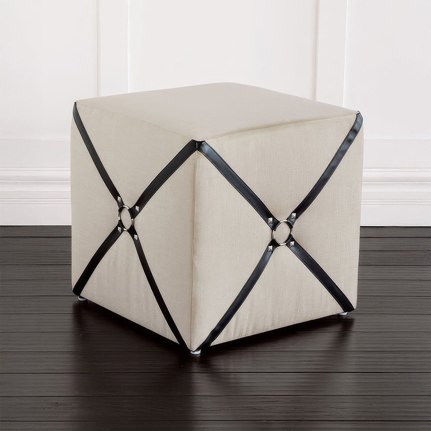 Harness cube ottoman on dark wooden floor.