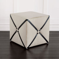 Harness cube ottoman on dark wooden floor.