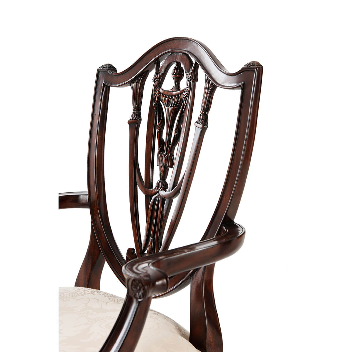 Close-up of ornate Hepplewhite armchair's shield back design.